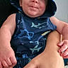 John is registered to the contest to win money with this photo: baby, infant, child, hoodie, blue_clothing, shark_pattern, cute, smiling, face, hands, adult_hand, indoor, portrait, young_child, casual_clothing, person, expression, happy, seated, holding