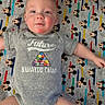 baby, infant, onesie, mickey_mouse, blanket, smiling, lying_down, child, cute, happy, indoor, portrait, clothing, pattern, head, face, person, small_child, wood, colorful