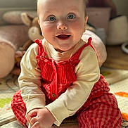 Mhiran is registered to the contest to win money with this photo: baby, child, smiling, red_clothing, striped, sitting, play_mat, indoor, soft_toys, happy, cute, portrait, infant, chubby_cheeks, bright_eyes, cozy, home, floor, long_sleeves, white_socks