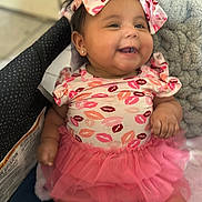 Delilah is registered to the contest to win money with this photo: baby, child, smiling, pink, tutu, headband, clothing, happy, cute, infant, earrings, sitting, portrait, face, person, apparel, soft, adorable, indoor, fun