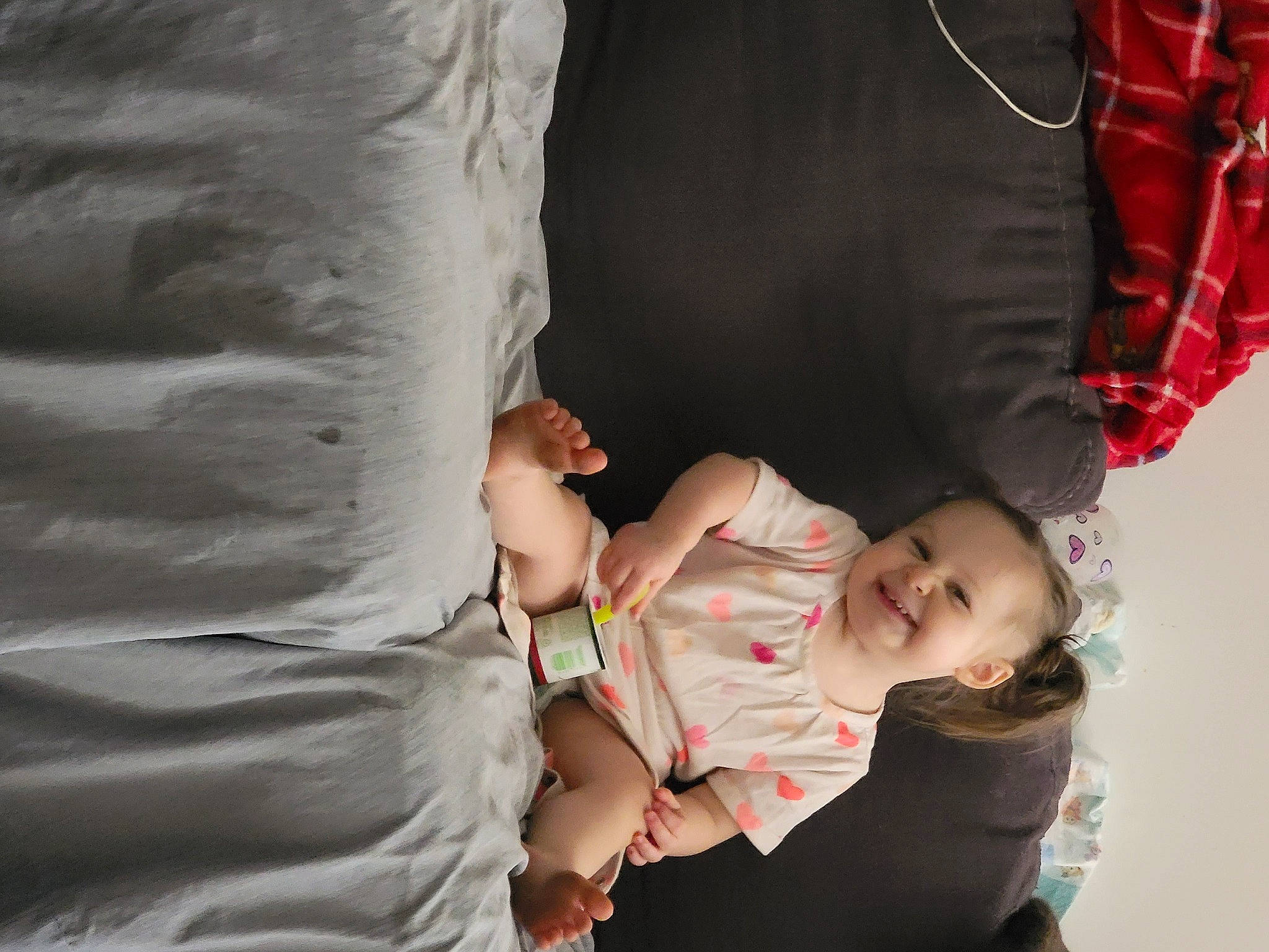 Sandra is registered to the contest to win money with this photo: abdomen, baby, baby_carriage, baby_products, baby_toddler_clothing, child, comfort, elbow, fun, gesture, hand, happy, human_leg, joy, linens, person, sitting, sleeve, t_shirt, toddler