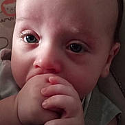 Mason is registered to the contest to win money with this photo: baby, infant, hand, face, eyes, blanket, animal_print, cute, child, portrait, skin, fingers, young, closeup, person, indoors, expression, sitting, soft, comfort