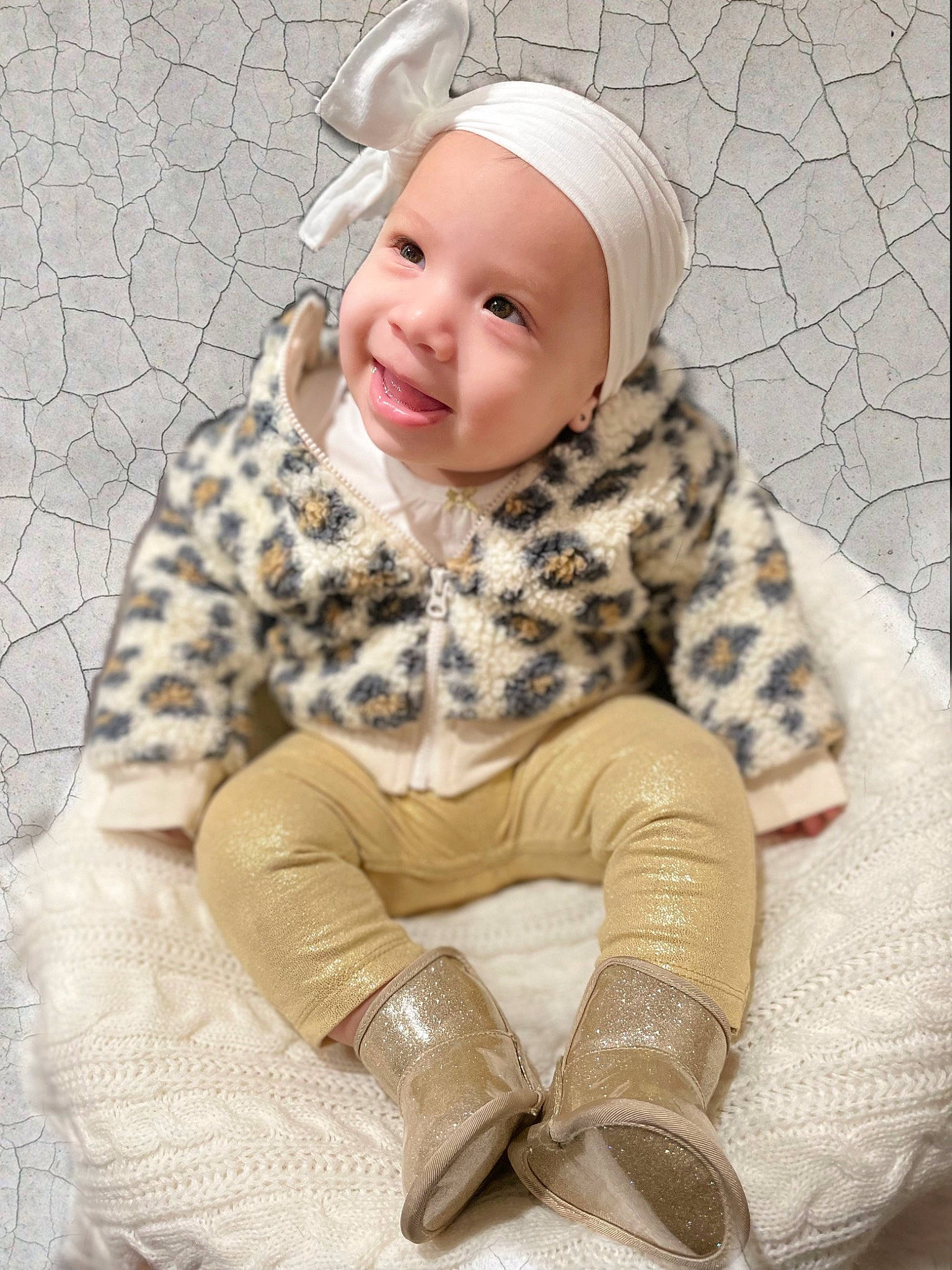 Kyomi is registered to the contest to win money with this photo: baby, baby_toddler_clothing, boot, cap, child, comfort, face, flooring, fur, happy, headgear, headwear, knee, outerwear, pattern, person, personal_protective_equipment, sitting, sleeve, smile