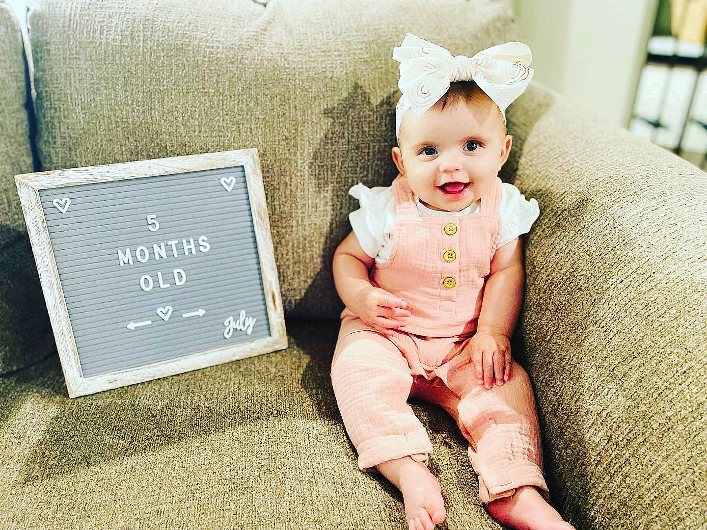 Becky is registered to the contest to win money with this photo: baby, baby_toddler_clothing, child, comfort, costume_hat, fashion_accessory, flash_photography, font, foot, fun, grass, happy, joy, person, portrait_photography, rectangle, room, sitting, sleeve, smile