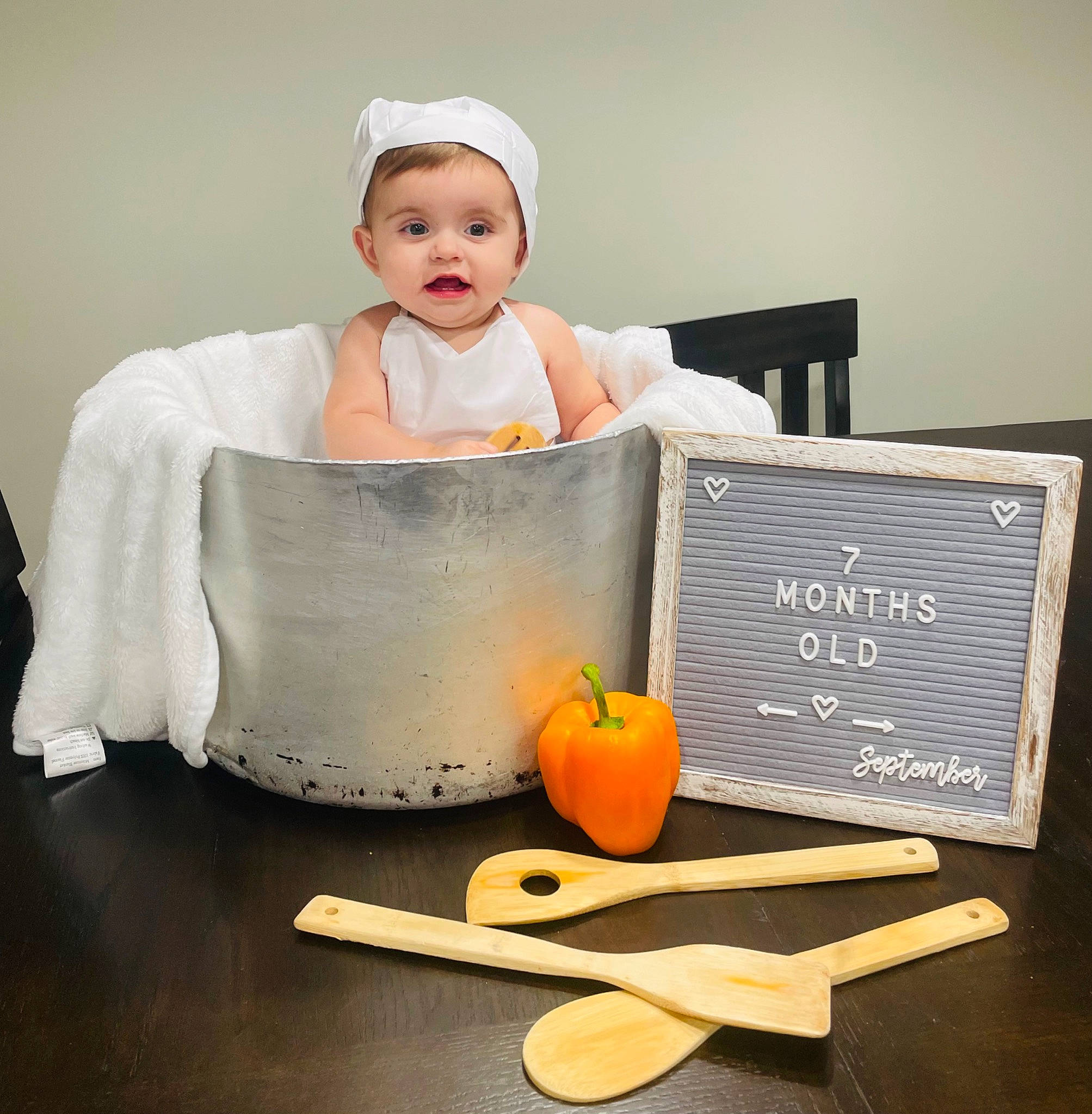 Becky is registered to the contest to win money with this photo: baby, baby_toddler_clothing, chair, flooring, food_group, fruit, happy, natural_foods, person, produce, pumpkin, recipe, room, serveware, sitting, sleeve, superfood, tableware, toddler, vegetable