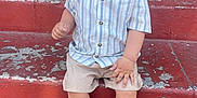 Juan is registered to the contest to win money with this photo: toddler, child, smiling, sitting, stairs, outdoor, sandals, shorts, striped_shirt, happy, face, hands, feet, steps, red, casual_clothing, cute, baby, person, portrait