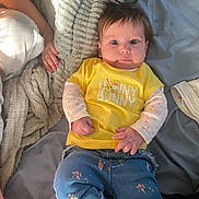 Wrenley joined the competition — help win amazing prizes! baby, infant, child, yellow_shirt, blue_pants, floral_pattern, blanket, bed, hand, soft_texture, face, eyes, hair, clothing, lying_down, indoors, cute, portrait, cozy, expression