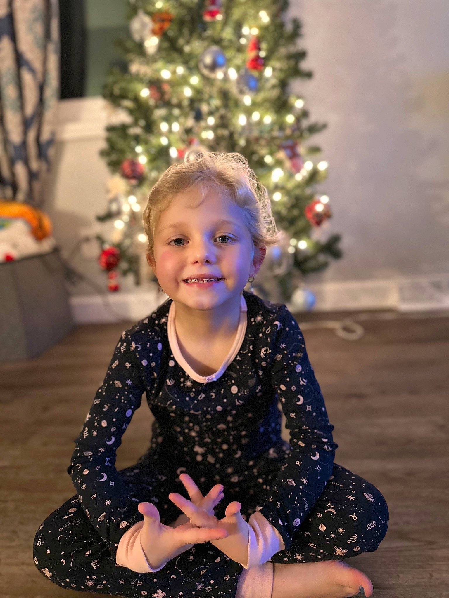 Addilynn joined the competition — help win amazing prizes! baby_toddler_clothing, christmas, christmas_decoration, christmas_ornament, christmas_tree, event, facial_expression, fun, hair, happy, head, holiday, holiday_ornament, joy, person, sitting, sleeve, smile, standing, toddler