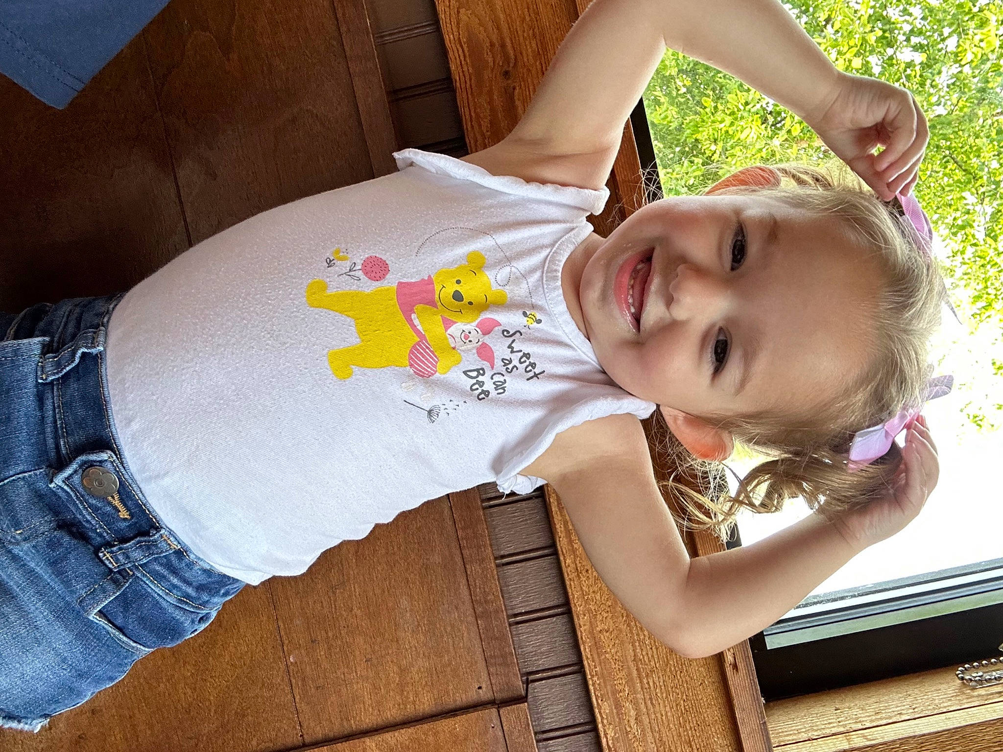 Olivia is registered to the contest to win money with this photo: arm, child, clothing, cool, design, finger, fun, grass, happy, human_body, joy, leisure, person, sitting, skin, smile, t_shirt, thigh, toddler, tree
