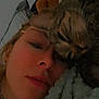person, cat, tabby_cat, glasses, blanket, plush_toy, close_up, indoor, face, resting, cozy, sleepy, snuggling, eyewear, nose_piercing, soft_texture, warm_lighting, bedroom, casual, intimate