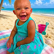 Lexi is registered to the contest to win money with this photo: toddler, beach, ocean, sand, palm_tree, blue_sky, clouds, bucket, shovel, seashell, starfish, towel, dress, child, smiling, happy, sunny, outdoor, play, vacation