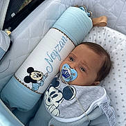 Neyzan participe au concours pour gagner de l'argent avec cette photo : baby, pacifier, mickey_mouse, pillow, stroller, bib, clothing, blue, quilted, star_pattern, face, person, infant, cute, resting, indoor, soft, comfort, child, toy