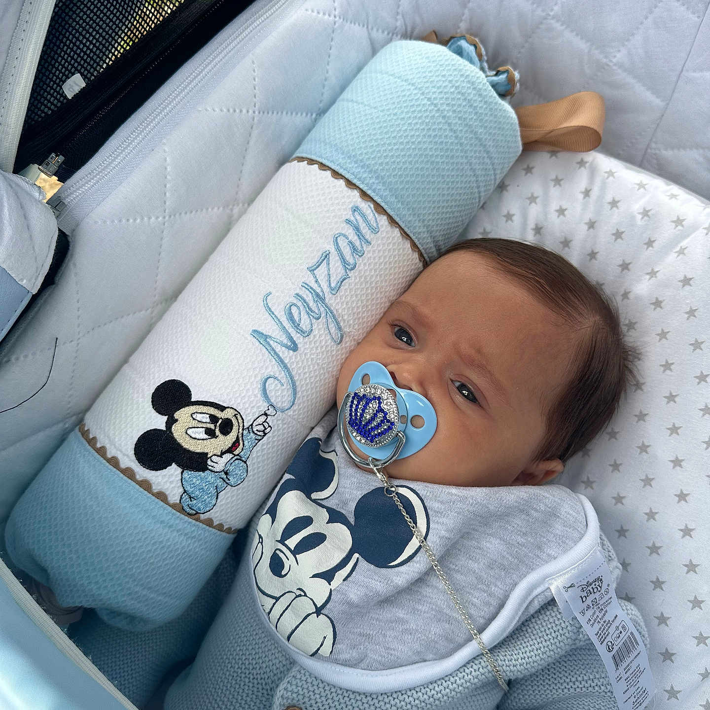 Neyzan participe au concours pour gagner de l'argent avec cette photo : baby, bib, blue, child, clothing, comfort, cute, face, indoor, infant, mickey_mouse, pacifier, person, pillow, quilted, resting, soft, star_pattern, stroller, toy