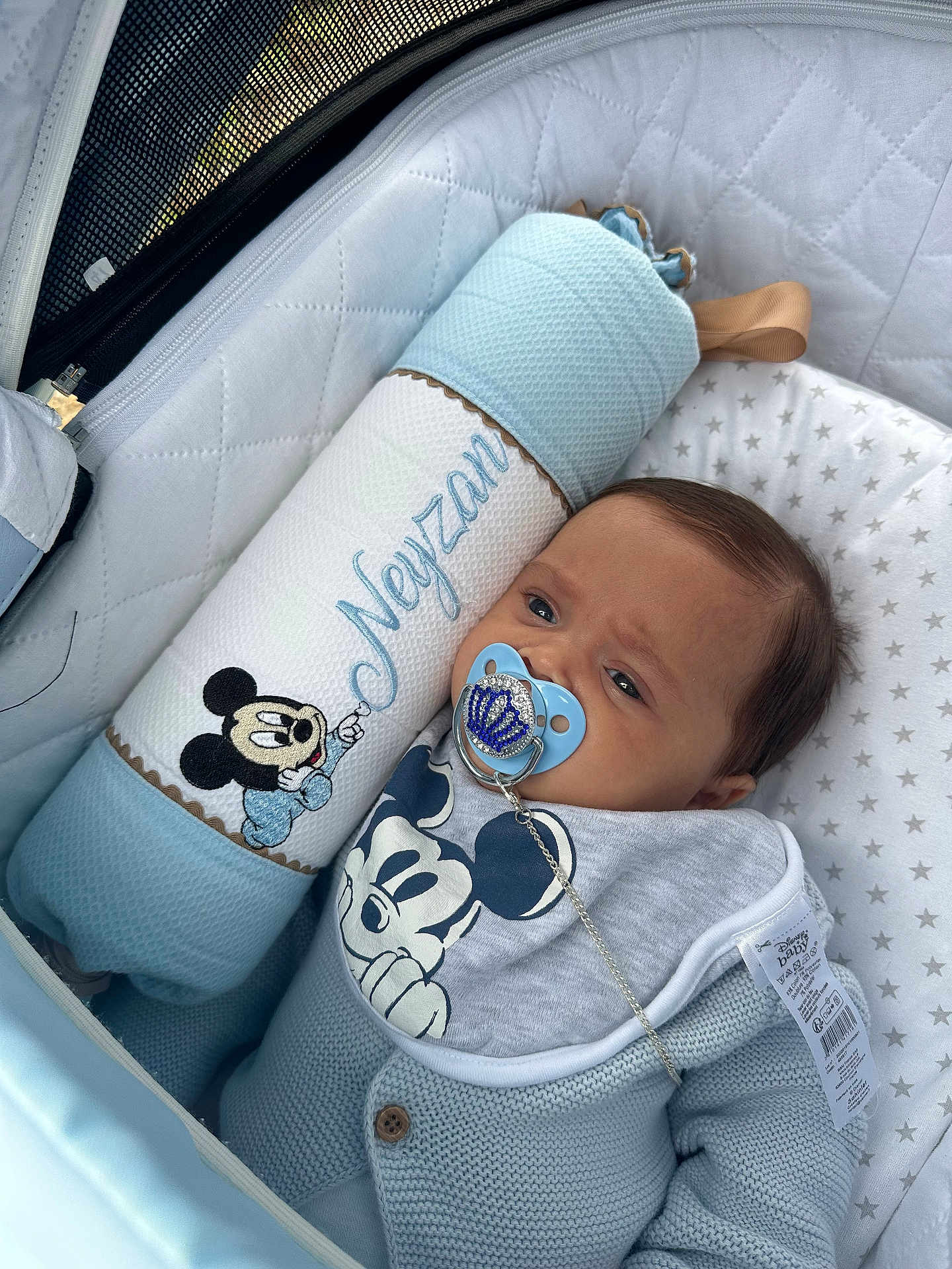 Neyzan participe au concours pour gagner de l'argent avec cette photo : baby, pacifier, mickey_mouse, pillow, stroller, bib, clothing, blue, quilted, star_pattern, face, person, infant, cute, resting, indoor, soft, comfort, child, toy