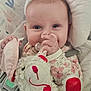Kara joined the competition — help win amazing prizes! baby, infant, teddy_bear, plush_toy, pacifier, onesie, floral_pattern, cushion, seat_belt, child, cute, smiling, indoors, soft_toy, hand, face, comfort, happy, close_up, portrait