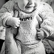 Kara joined the competition — help win amazing prizes! baby, child, smile, happy, tattoo, hand, arm, clothing, fluffy, texture, portrait, indoor, person, cute, infant, holding, warm, cozy, black_and_white, close_up