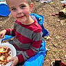 child, boy, outdoor, smiling, chair, blue_chair, plate, food, sweater, red_and_gray, toy, slide, shoes, mickey_mouse, ground, dirt, playground, happy, face, person