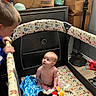 James joined the competition — help win amazing prizes! baby, baby_boy, blanket, bottle, cardboard_box, child, clothing, curious, floor, furniture, home, indoor, interaction, lamp, looking_up, mickey_mouse_toy, person, playpen, toddler, toy