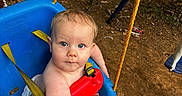 James is registered to the contest to win money with this photo: baby, blue_swing, child, cute, diaper, dirt_ground, grass, infant, nature, outdoor, person, play, playground, red_safety_bar, rope, seat, swing, toddler, trees, yellow_rope