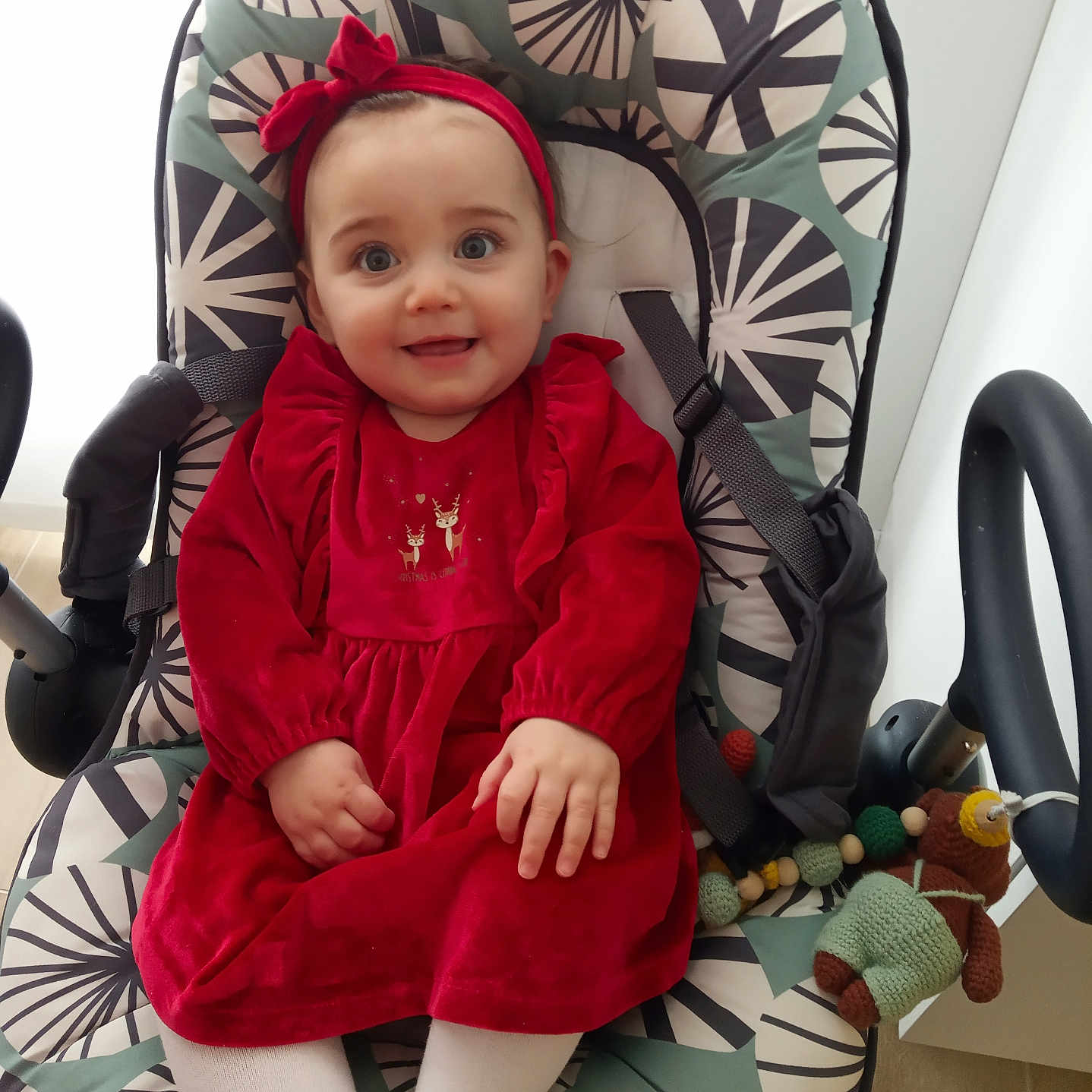 Margot a rejoint le concours — aidez-le/la à gagner de superbes lots ! baby, baby_rocker, blue_eyes, child, cozy, cute, face, happy, headband, indoor, infant, knitted_toy, patterned_fabric, portrait, red_dress, seat, small_hands, smile, toy, white_tights