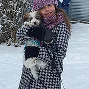 Josie is registered to the contest to win money with this photo: child, girl, dogs, puppies, small_dogs, snow, winter, outdoor, smiling, portrait, hats, winter_clothing, coat, scarf, gloves, purple_pants, leashes, house, snowy_background, pet_carrying