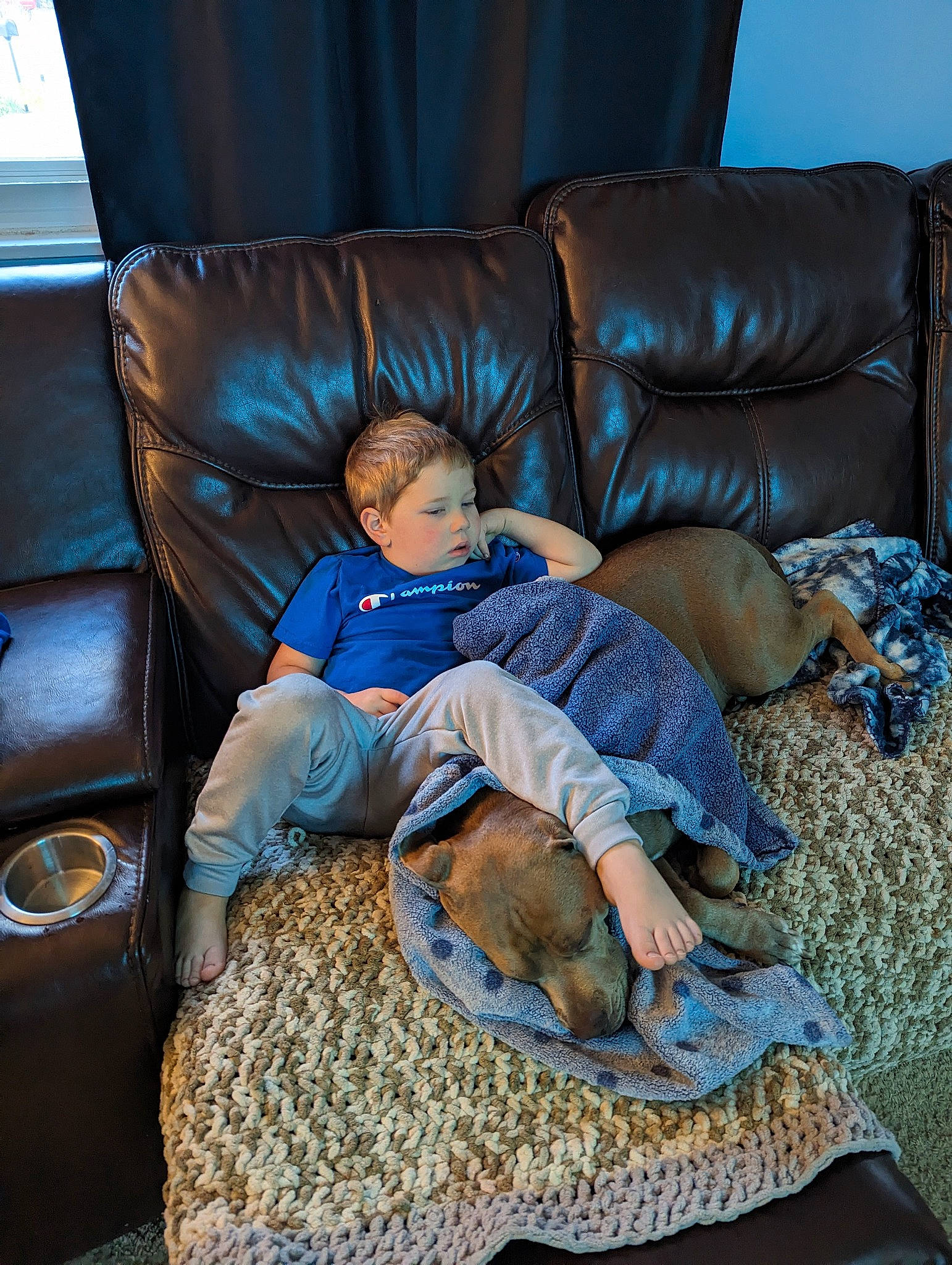Cash is registered to the contest to win money with this photo: azure, baby, comfort, couch, electric_blue, flooring, fun, furniture, lap, leisure, linens, living_room, mammal, room, sitting, sofa_bed, studio_couch, throw_pillow, toddler, wood