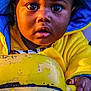 toddler, child, face, eyes, hoodie, yellow_clothing, blue_clothing, hand, curious, close_up, portrait, outdoor, toy, grip, expression, young_child, skin, person, baby, clothing