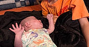 Aerith joined the competition — help win amazing prizes! baby, baby_clothing, blanket, brother, child, couch, cozy, family, happy, indoor, infant, lying_down, newborn, orange_shirt, portrait, siblings, sister, sitting, smiling, yellow_shorts