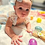 baby, blanket, bow, child, closeup, clothing, colorful, cute, expression, eyes, face, hand, headband, indoor, infant, playtime, portrait, skin, soft, toy