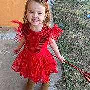 Michaela joined the competition — help win amazing prizes! child, girl, costume, devil, red_dress, headband, horns, trident, outdoor, grass, concrete, boots, smiling, happy, person, playful, holiday, cute, portrait, daylight