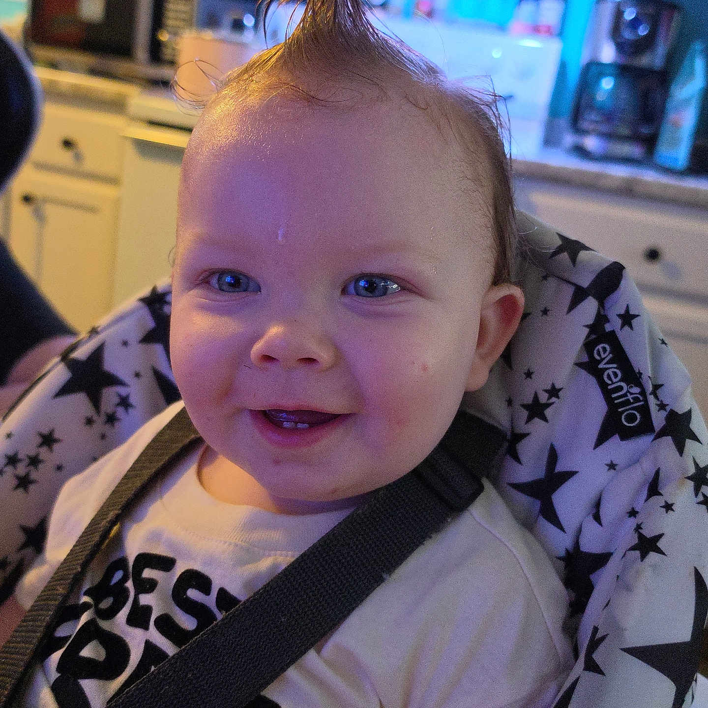 Finn joined the competition — help win amazing prizes! baby, child, smiling, mohawk, high_chair, straps, indoor, kitchen, face, blue_eyes, clothing, person, seat, patterned_fabric, happy, toddler, cute, expression, hair, infant