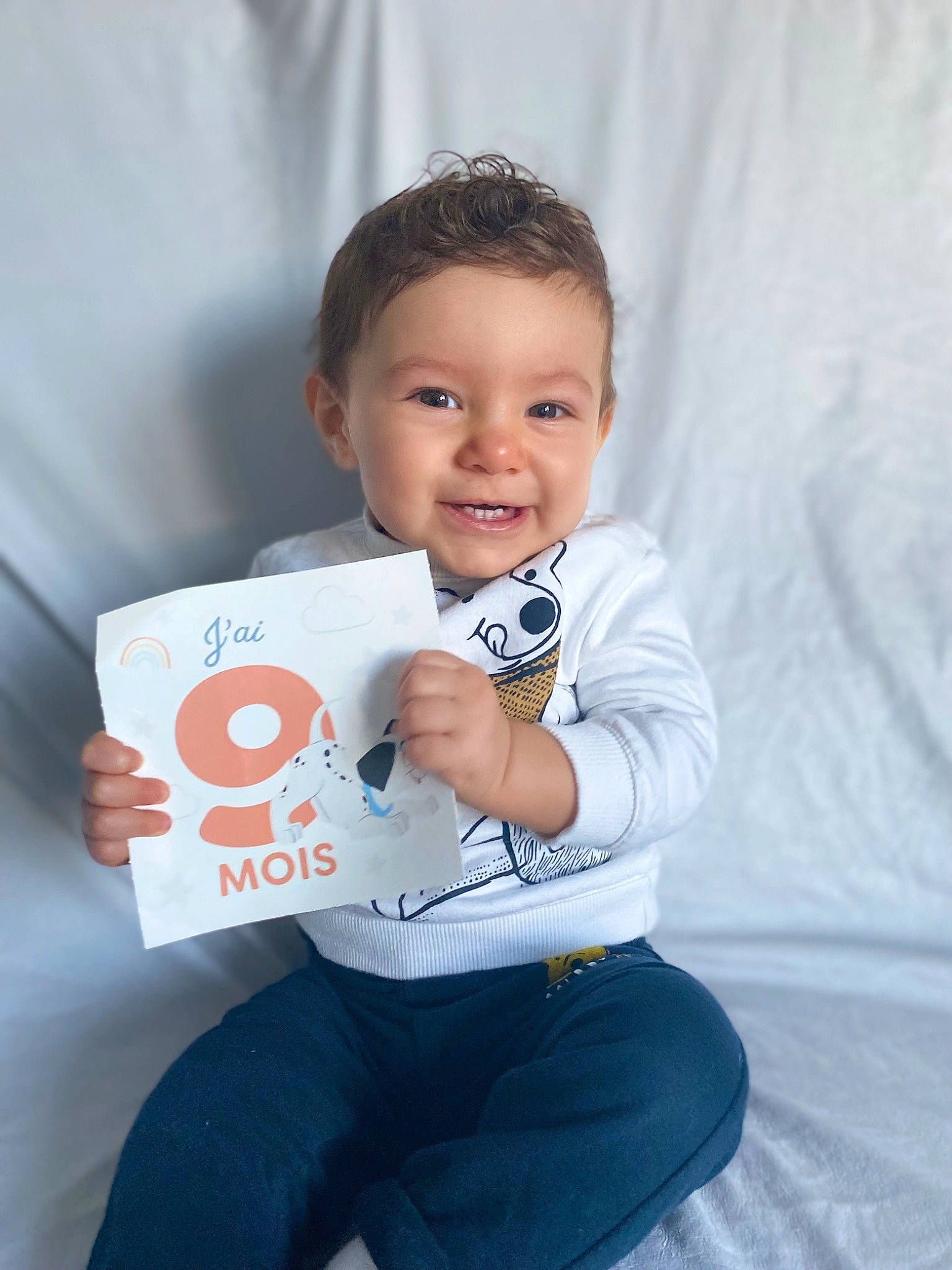Wellan a rejoint le concours — aidez-le/la à gagner de superbes lots ! baby, baby_toddler_clothing, cheek, child, comfort, denim, electric_blue, flash_photography, fun, happy, jeans, joy, logo, person, photo_shoot, portrait_photography, sitting, sleeve, smile, t_shirt