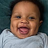 baby, smiling, closeup, face, infant, blue_shirt, happy, cute, child, portrait, skin, eyes, mouth, teeth, drool, dimples, hair, laying, background, expression