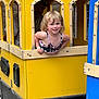 Serenity joined the competition — help win amazing prizes! child, smiling, play_vehicle, yellow, window, man, adult, outdoor, fun, happy, curly_hair, person, toy, playground, casual_clothing, daylight, face, leisure, joy, wood