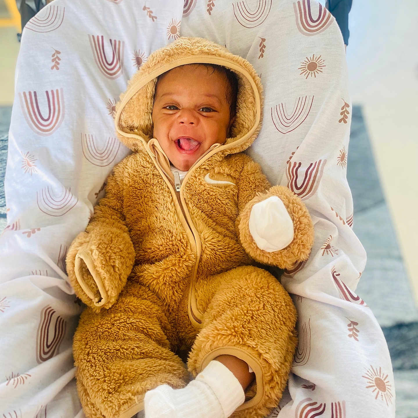 Samuela joined the competition — help win amazing prizes! baby, baby_boy, blanket, child, cozy, cute, cute_expression, fluffy_clothing, happy, hooded_jumpsuit, indoors, infant, onesie, patterned_blanket, portrait, seated, smiling, soft_texture, warm, white_socks
