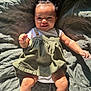 Skyler is registered to the contest to win money with this photo: baby, child, smiling, infant, top_knot, green_dress, button_straps, white_onesie, blanket, textured, leaf_pattern, sunlight, shadow, happy, cute, legs, arms, skin, indoors, portrait