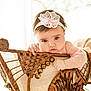 baby, child, headband, pink, lace, wicker, chair, hand, face, eyes, portrait, indoor, cute, infant, furniture, soft_light, expression, person, young, candid
