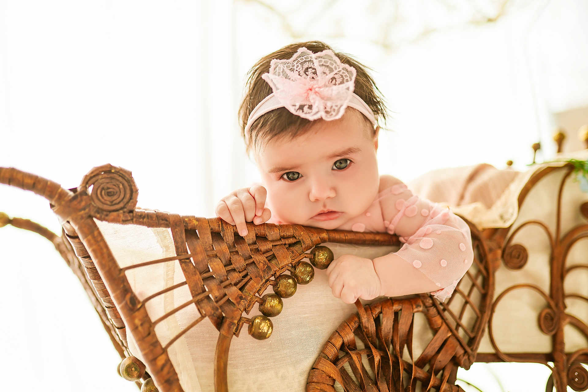 Ena participe au concours pour gagner de l'argent avec cette photo : baby, child, headband, pink, lace, wicker, chair, hand, face, eyes, portrait, indoor, cute, infant, furniture, soft_light, expression, person, young, candid