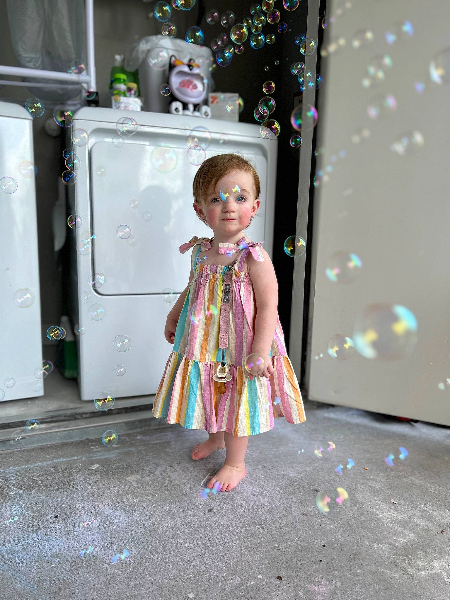 Penelope is registered to the contest to win money with this photo: child, day_dress, doll, door, dress, fashion_design, foot, formal_wear, fun, human_leg, machine, magenta, one_piece_garment, pattern, person, pink, room, sandal, standing, toy