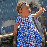 Liliana joined the competition — help win amazing prizes! toddler, child, stroller, blue_dress, hello_kitty, headband, outdoor, sunlight, fence, folding_chair, water_bottle, curious, baby, person, sitting, casual, playful, daylight, portrait, clothing