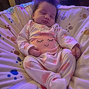 Daisy-Mae is registered to the contest to win money with this photo: baby, sleeping, infant, pajamas, pink, cushion, indoor, child, cozy, soft_lighting, face, hands, footed_pajamas, wooden_furniture, blanket, peaceful, cute, relaxed, home, resting