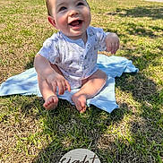 Holden is registered to the contest to win money with this photo: baby, infant, eight_months, grass, outdoor, smiling, happy, sunlight, blanket, milestone, sign, child, cute, portrait, sitting, casual, clothing, nature, daylight, joyful
