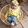 baby, infant, smiling, yellow_sweater, denim_pants, headband, flower, wicker_chair, lace, dried_pampas_grass, wooden_floor, cute, portrait, indoor, child, happy, cozy, fashion, sitting, person