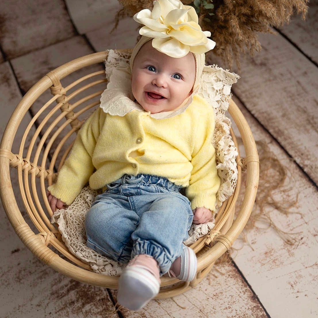 Fidjy participe au concours pour gagner de l'argent avec cette photo : baby, infant, smiling, yellow_sweater, denim_pants, headband, flower, wicker_chair, lace, dried_pampas_grass, wooden_floor, cute, portrait, indoor, child, happy, cozy, fashion, sitting, person