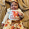Aniree is registered to the contest to win money with this photo: baby, blanket, bow, child, clothing, cute, face, festive, hand, happy, headband, indoors, infant, knitted, long_sleeve, pattern, person, skirt, smile, thanksgiving