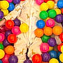 baby, child, smiling, colorful, plastic_balls, onesie, giraffe_pattern, elephant_pattern, playtime, indoor, happy, cute, feet, hands, face, toy, multicolor, fun, infant, portrait