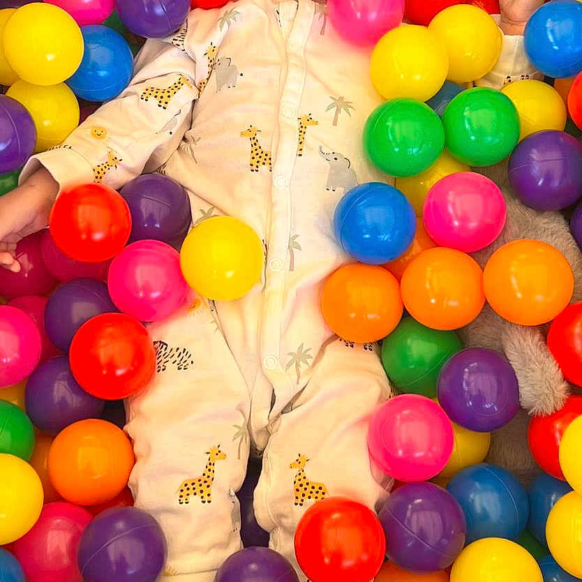 Fin participe au concours pour gagner de l'argent avec cette photo : baby, child, colorful, cute, elephant_pattern, face, feet, fun, giraffe_pattern, hands, happy, indoor, infant, multicolor, onesie, plastic_balls, playtime, portrait, smiling, toy