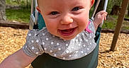 Zella joined the competition — help win amazing prizes! baby, baby_clothing, child, daytime, face, fun, happy, nature, outdoor, person, pink_pants, play, playground, polka_dot, shirt, smiling, sunlight, swing, trees, wood_chips