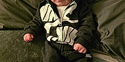 Hadlee Skye is registered to the contest to win money with this photo: baby, bodypart, clothing, coat, couch, cushion, face, finger, furniture, hand, head, homedecor, jacket, knitwear, pants, person, photography, portrait, sitting, sweater