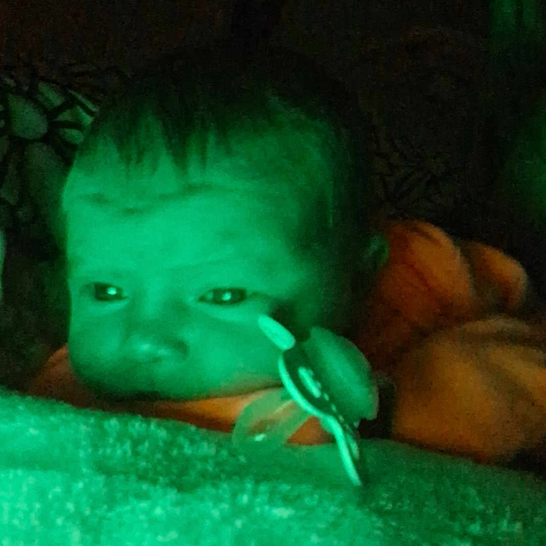 Chloe is registered to the contest to win money with this photo: baby, infant, child, face, eyes, pacifier, pacifier_clip, blanket, fuzzy_blanket, sleeping, bed, bedding, portrait, close_up, indoor, night, green_lighting, low_light, cozy, photograph